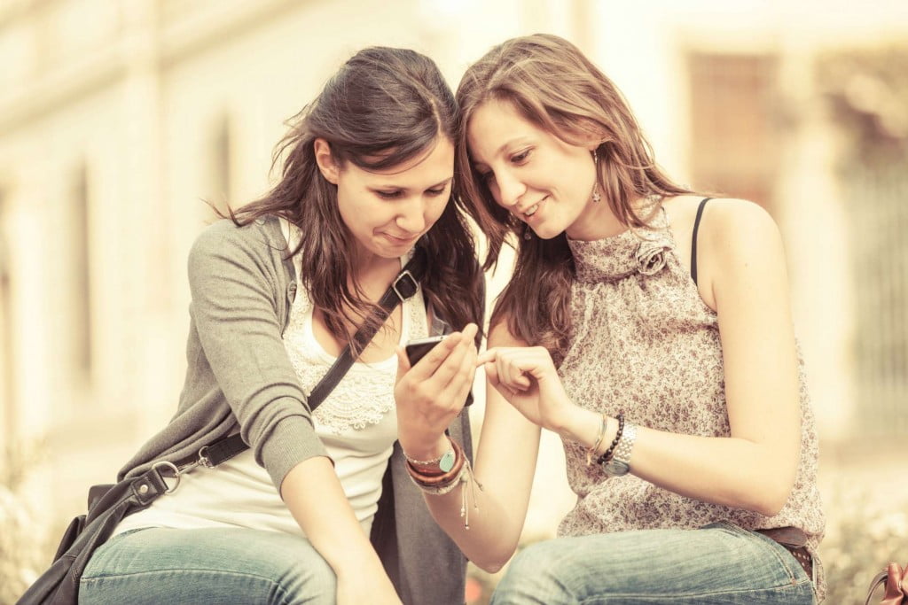 Two Beautiful Women Sending Messages with Mobile